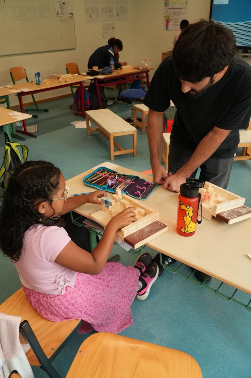 Klassenraum, in dem Kinder an Tischen bauen