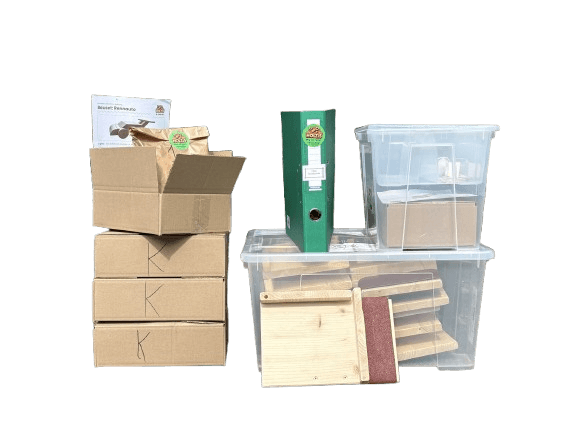 Das Schulpaket der Holzis: Kartons mit Bauteilen, Ordner mit Anleitungen, Kisten mit Werkbänken