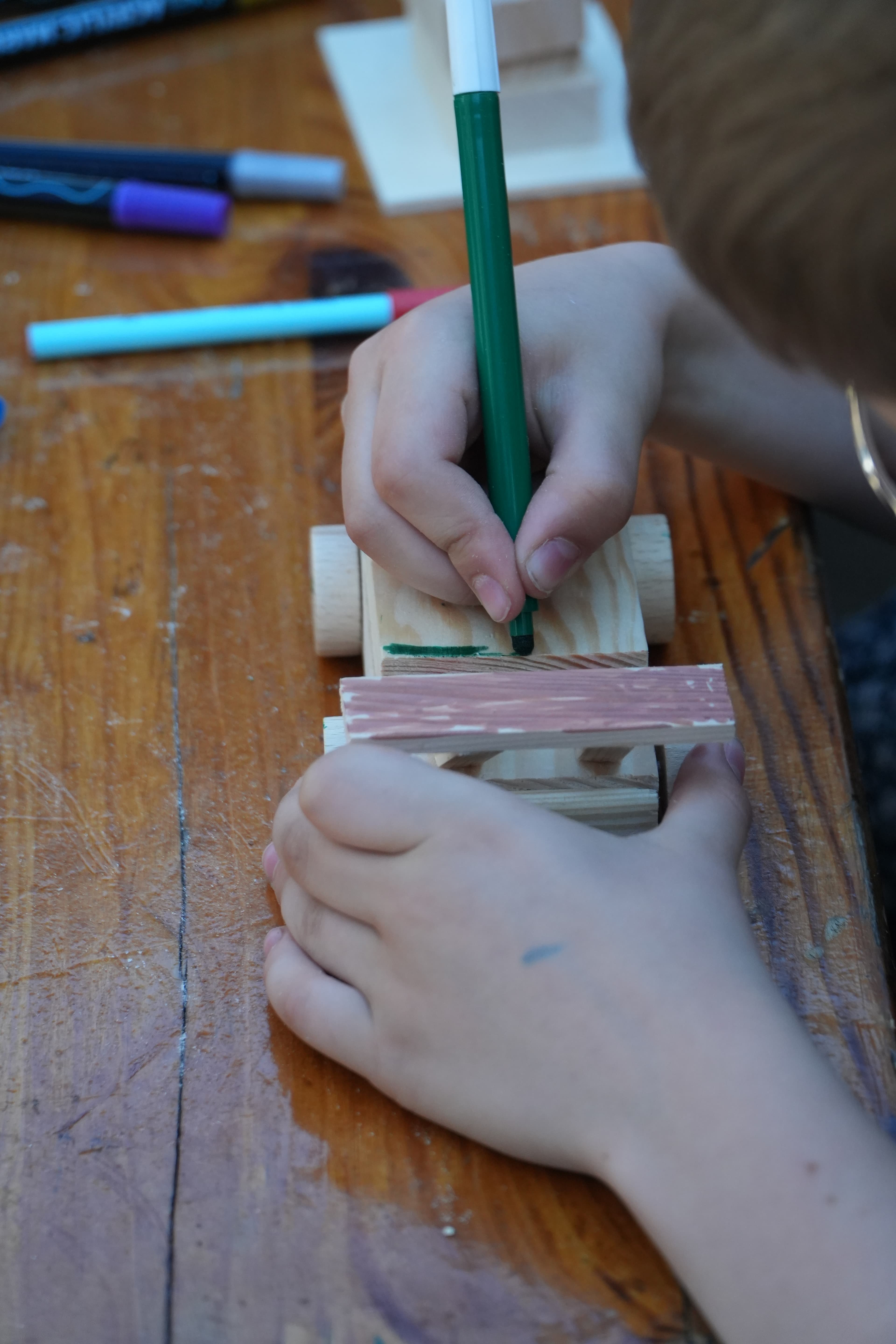 Kind baut konzentriert sein Holzprojekt zuhause