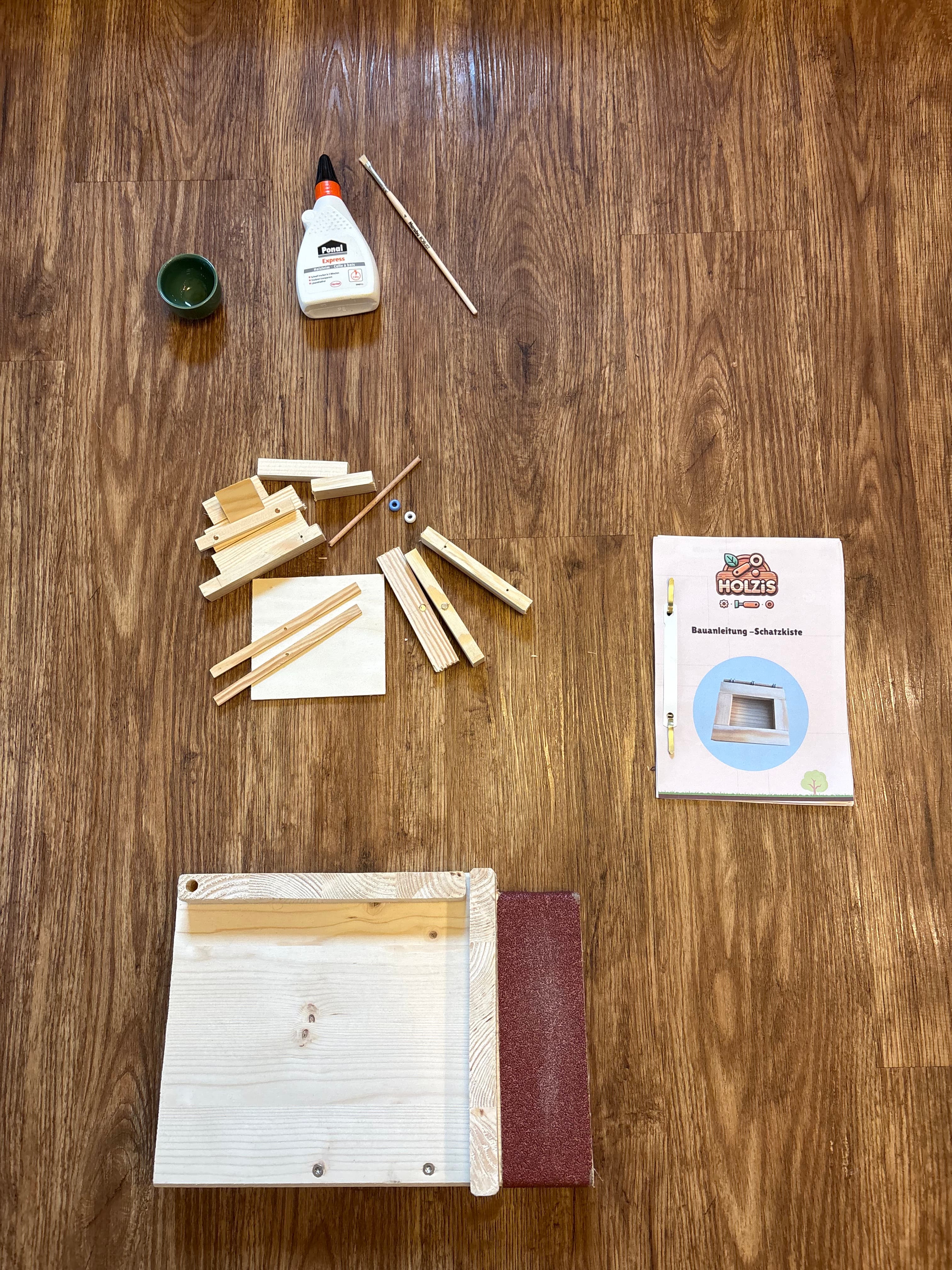 Inhalt des Holzi-Starter-Sets: Werkbank, Holzteile, Anleitung, Leim